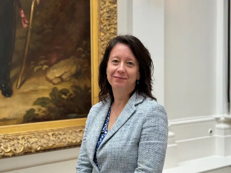 Academic in front of Painting with arms clasped