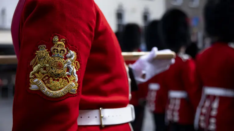 A ceremonial badge depicting the wearer's rank is worn on the arm of the soldier's red tunic.