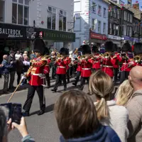 Soldiers in red tunics and black bearskin hats march through Berwick-upon-Tweed.
