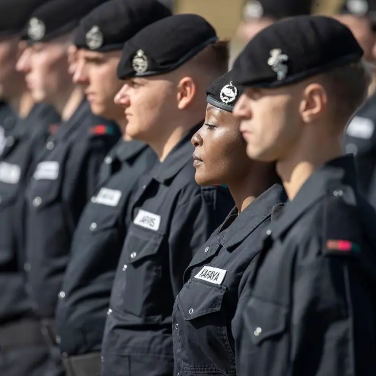 Soldiers wearing black coveralls stand on a parade.