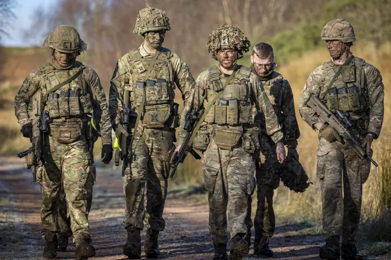 Several soldiers in uniform are pictured walking side by side.