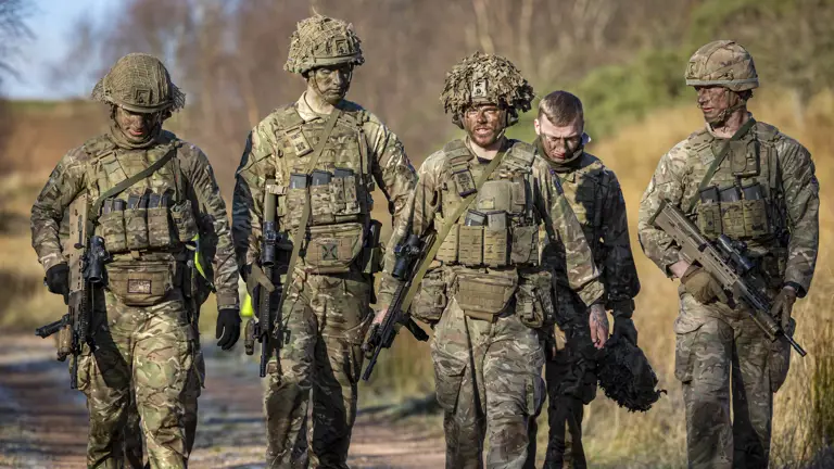 Several soldiers in uniform are pictured walking side by side.