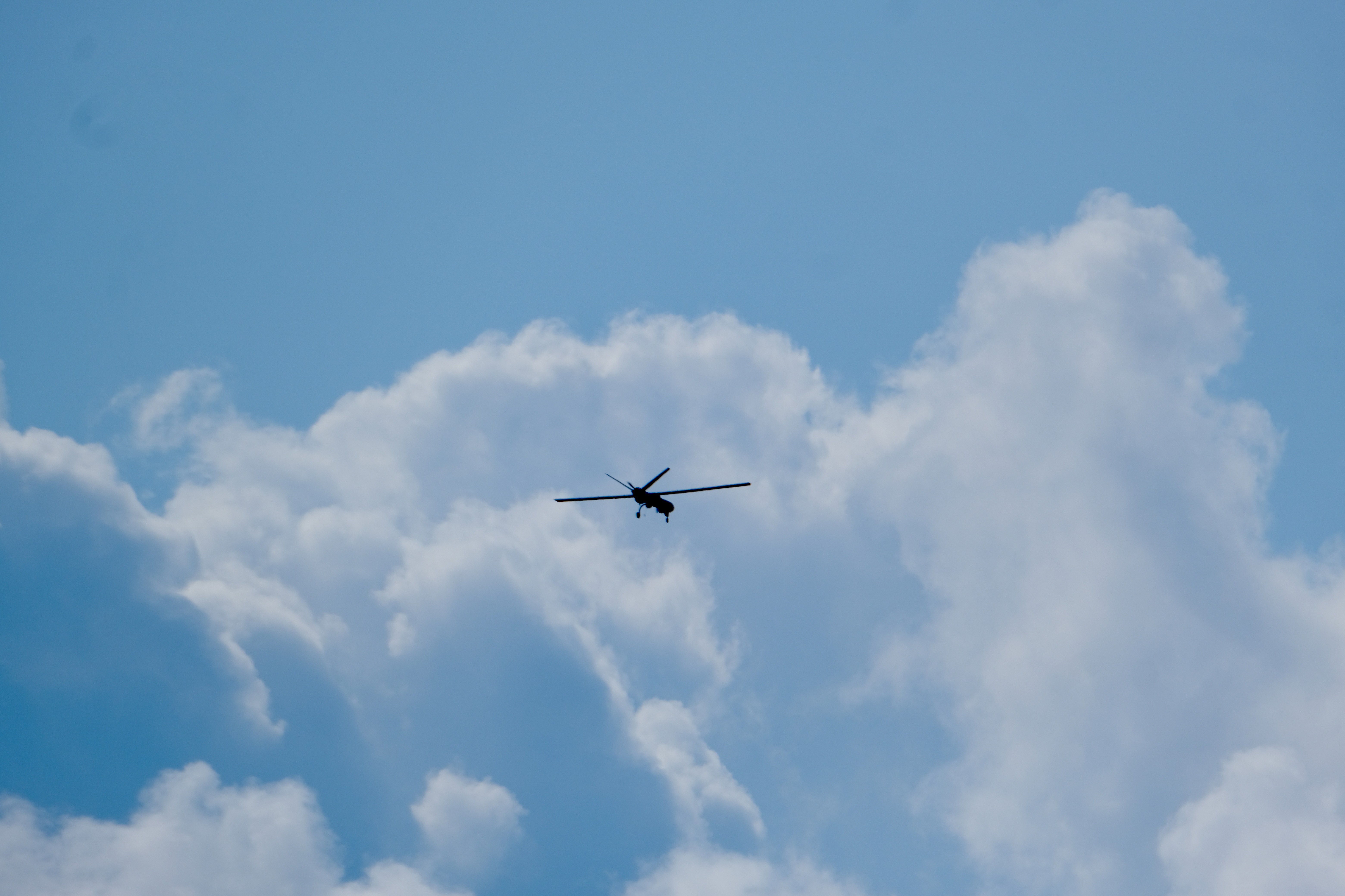 An unmanned aerial vehicle is pictured flying high in the sky.