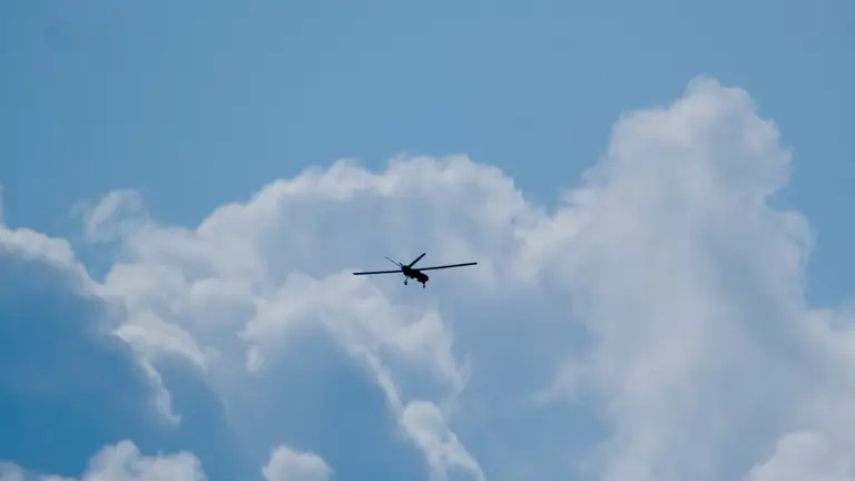 An unmanned aerial vehicle is pictured flying high in the sky.