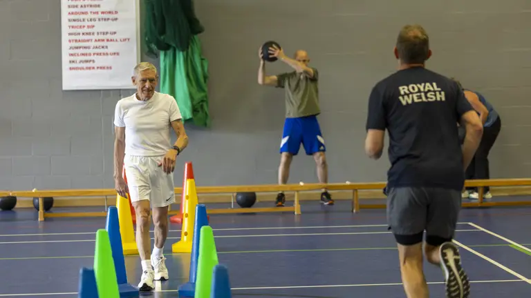 People wearing fitness clothes take part in a circuit during a fitness class.
