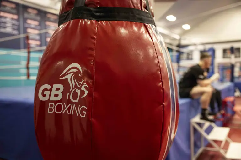 A red boxing bag shows a white lion and text that reads 'GB Boxing'.