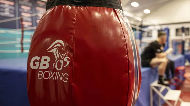A red boxing bag shows a white lion and text that reads 'GB Boxing'.
