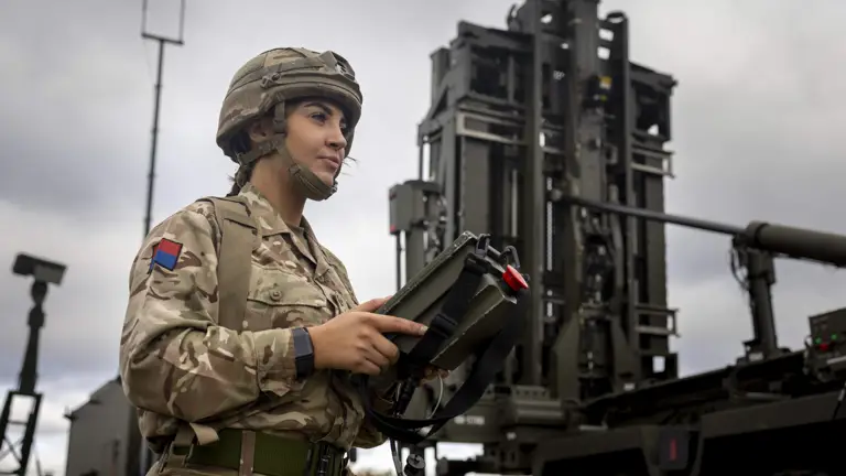 A soldier in uniform operates a missile delivery system.