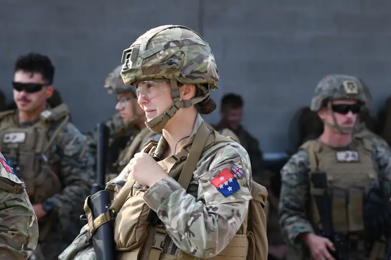 A group of military personnel in camouflage uniforms and helmet.
