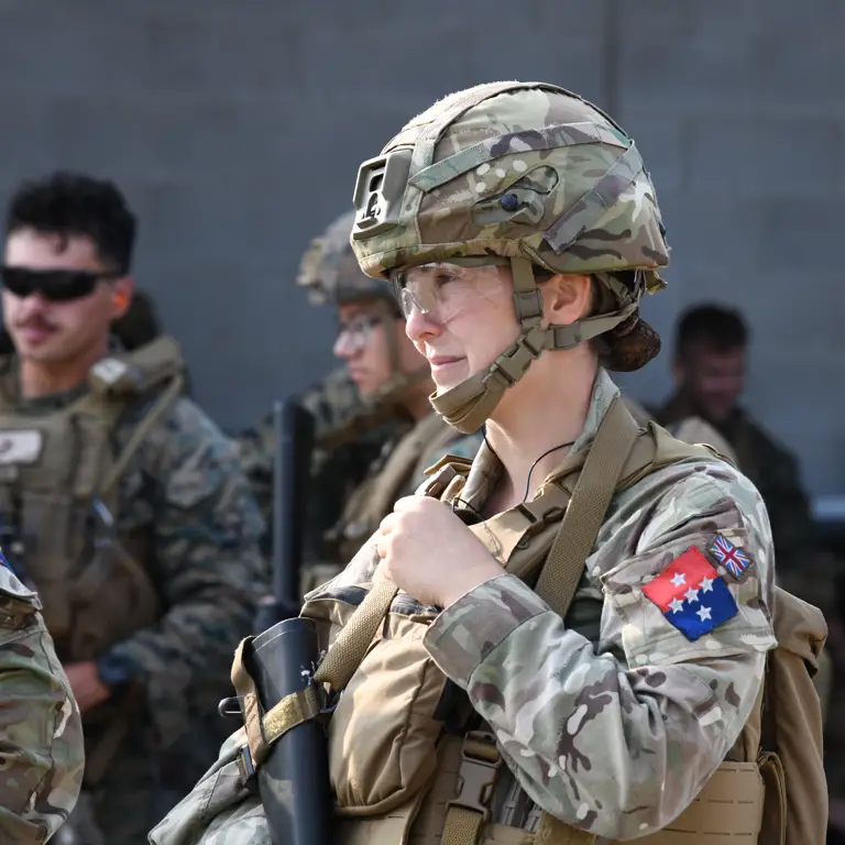A group of military personnel in camouflage uniforms and helmet.