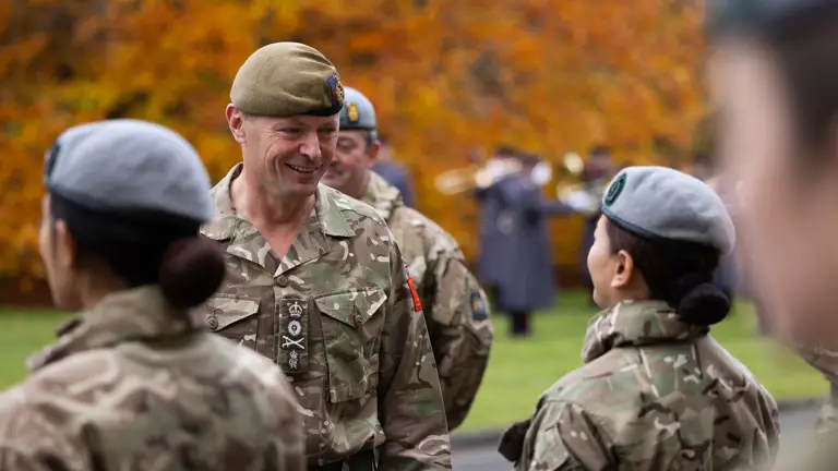 A senior Army Officer smiles at a lady in uniform.