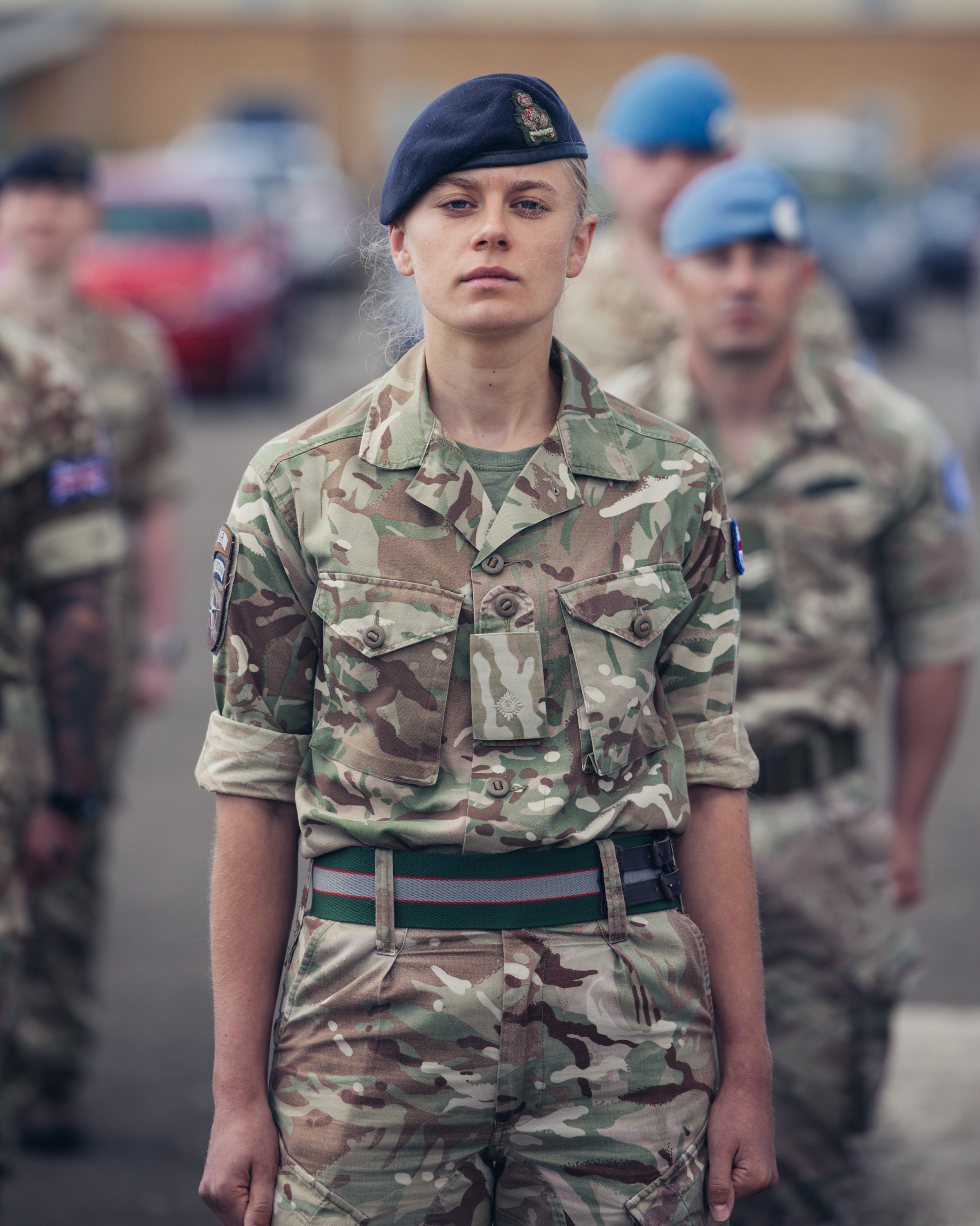 A soldier in uniform stands upright for a portrait. 