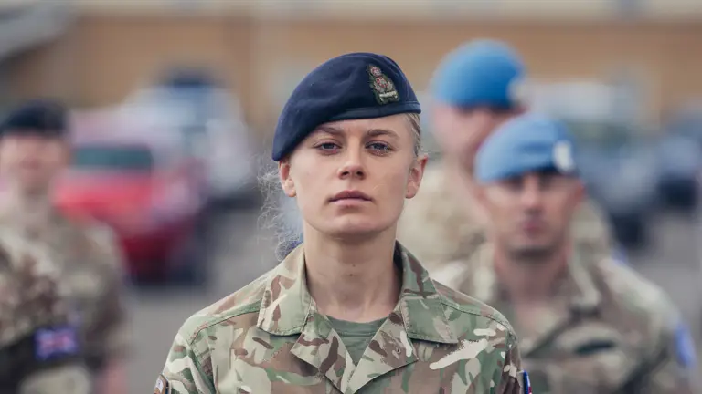 A soldier in uniform stands upright for a portrait.