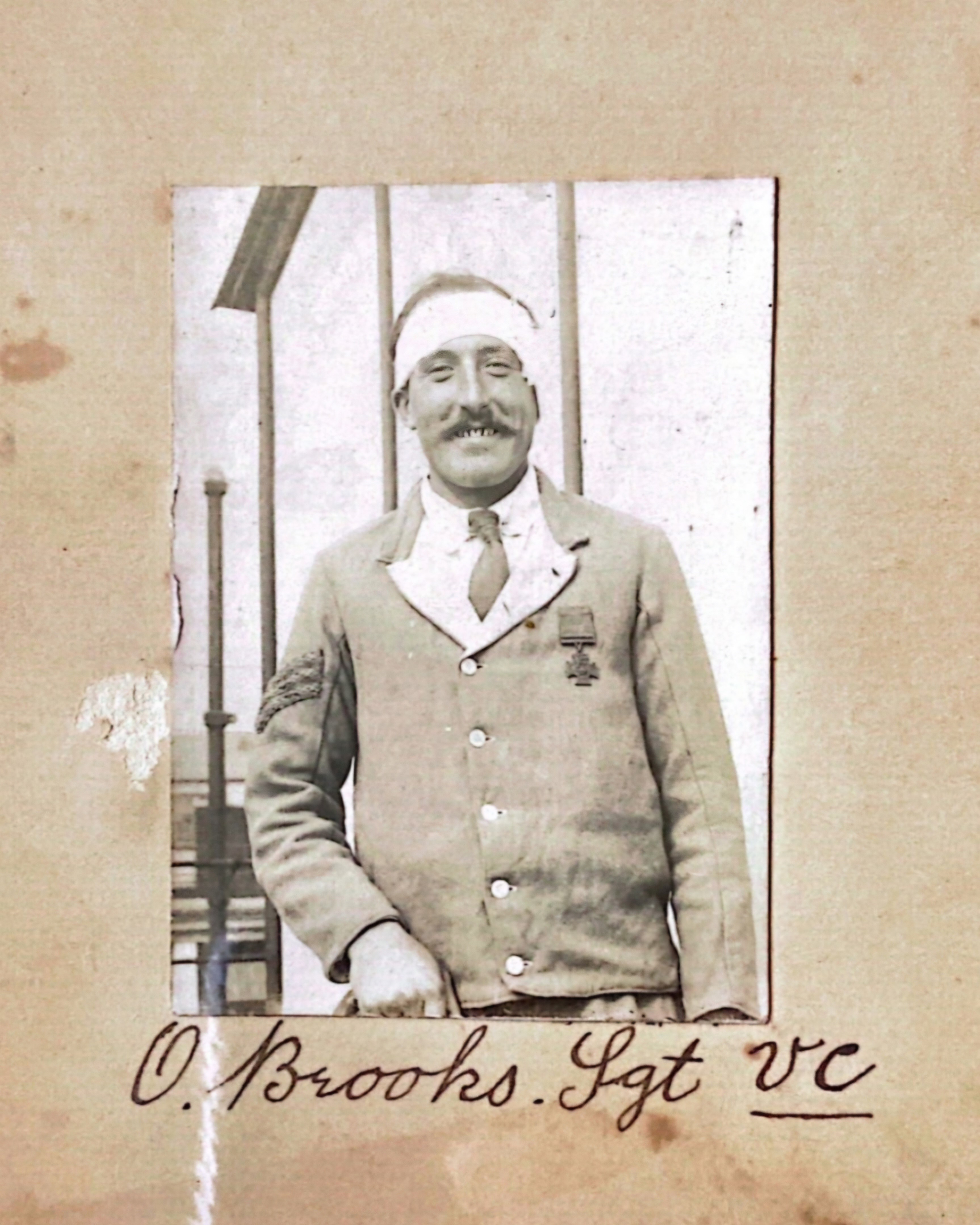 A historical image of a man wearing the Victoria Cross medal, his head is bandaged. 