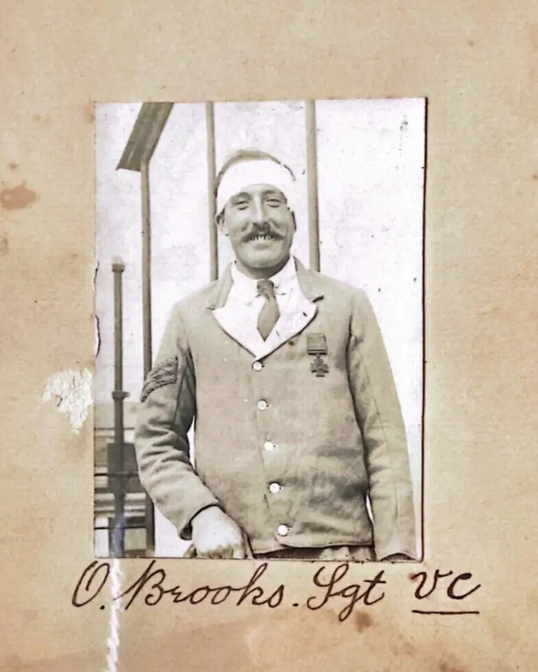 A historical image of a man wearing the Victoria Cross medal, his head is bandaged.