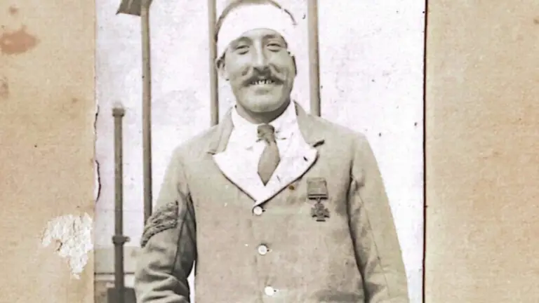 A historical image of a man wearing the Victoria Cross medal, his head is bandaged.
