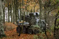 A green uncrewed vehicle sits in a woodblock.