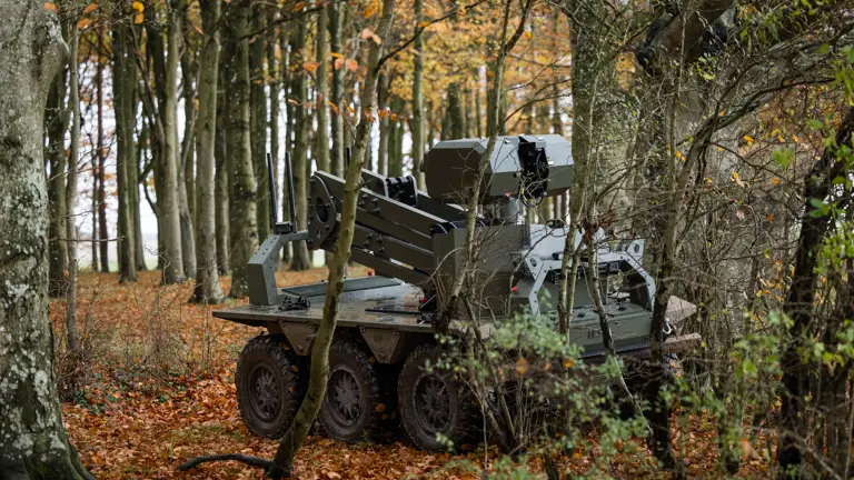 A green uncrewed vehicle sits in a woodblock.