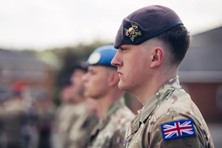 A side profile shot of a soldier in uniform, the cap badge (logo) of The Royal Lancers is visible.