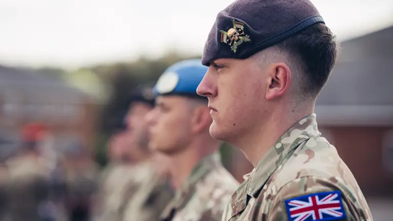A side profile shot of a soldier in uniform, the cap badge (logo) of The Royal Lancers is visible.