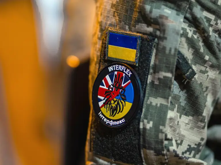 A camouflage-patterned uniform with a patch displaying the Ukrainian flag and an