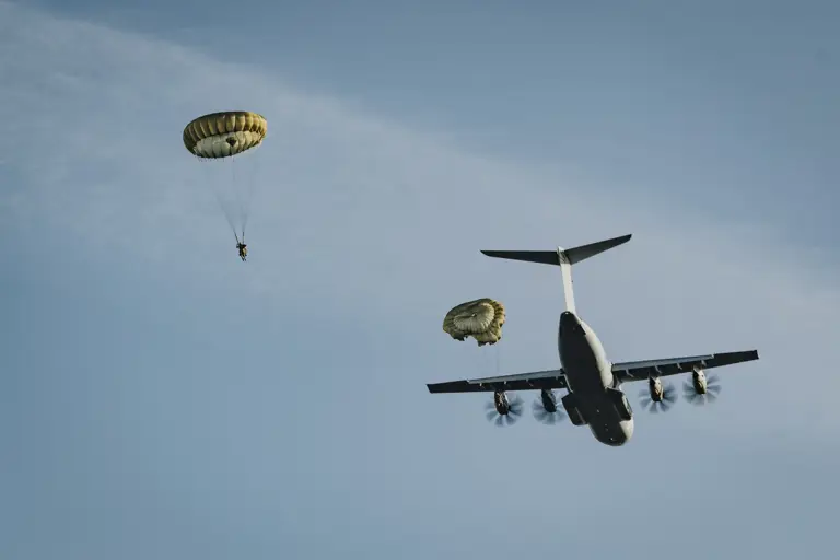 Two paratroopers are seen descending after jumping from a United States A400 aircraft