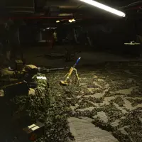 A drone is pictured flying through an artificially created war zone, mortar is located beneath the drone.