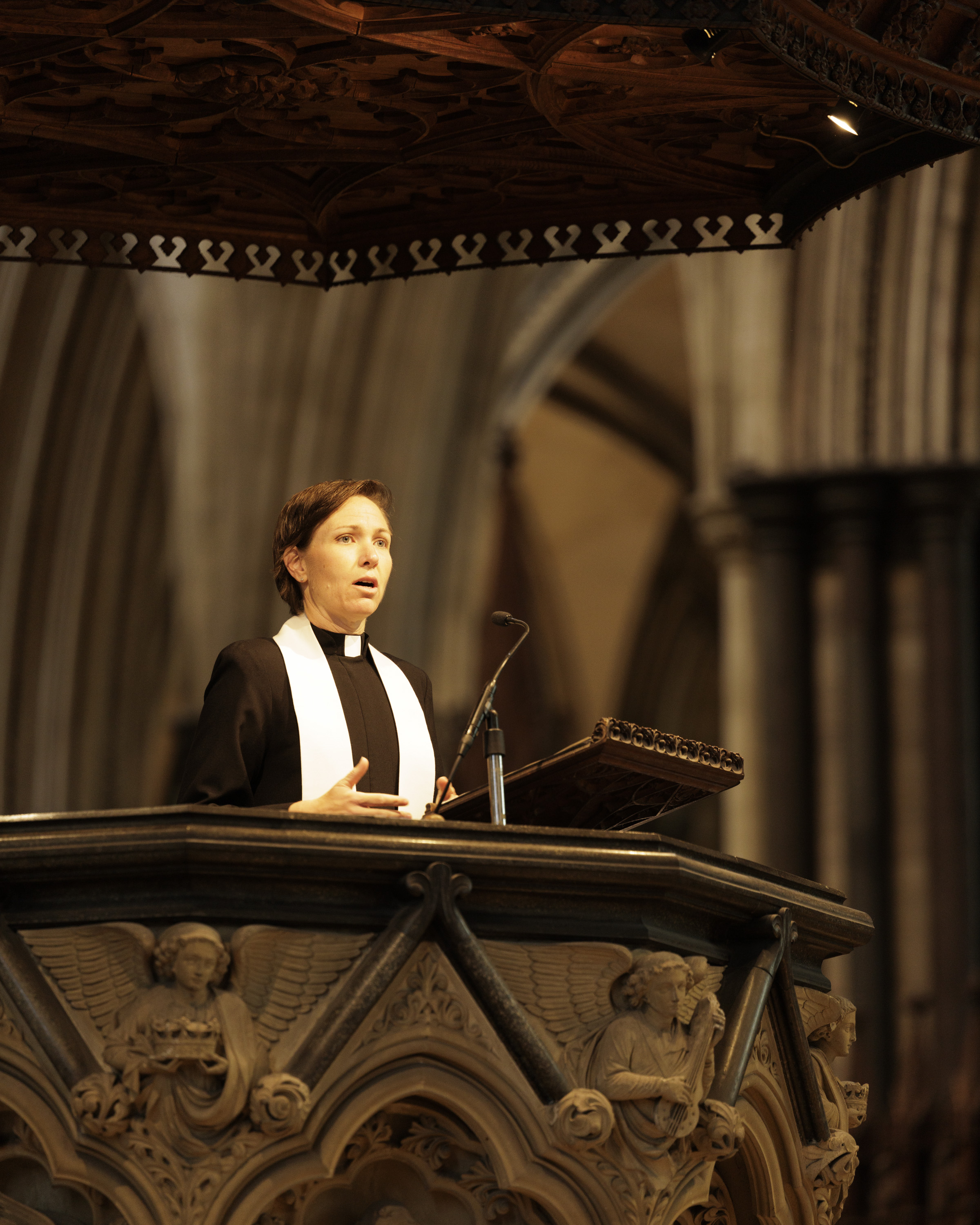 A woman delivers a sermon, she is wearing Christian religious dress.