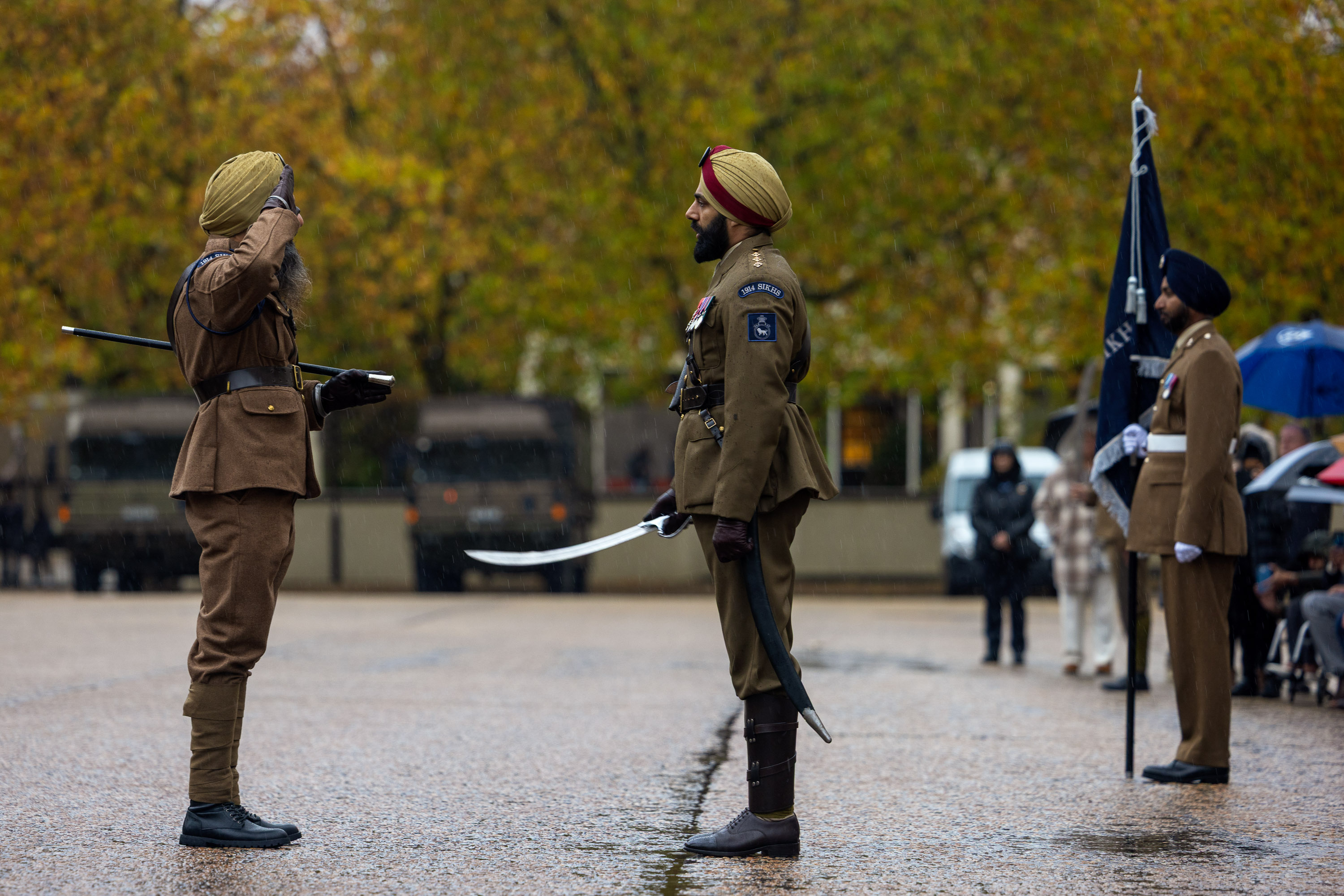 Two soldiers in brown uniforms face each other during a formal salute.