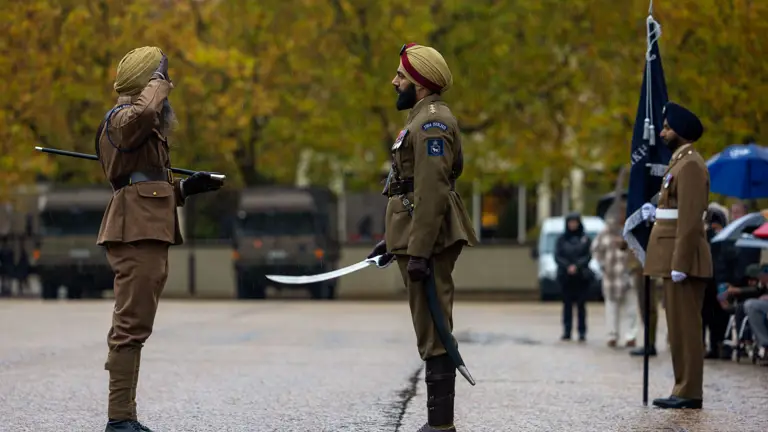 Two soldiers in brown uniforms face each other during a formal salute.