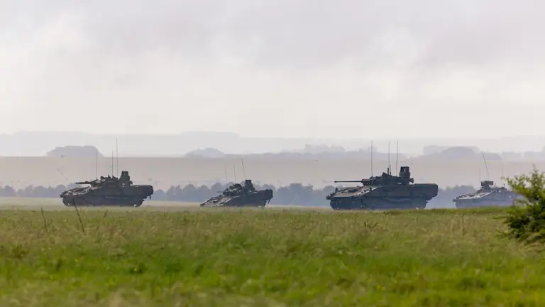 Four armoured vehicles are pictured against a backdrop of grass plains.