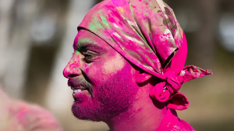 A close up of a Sikh British Army soldier covered in pink neon powder.