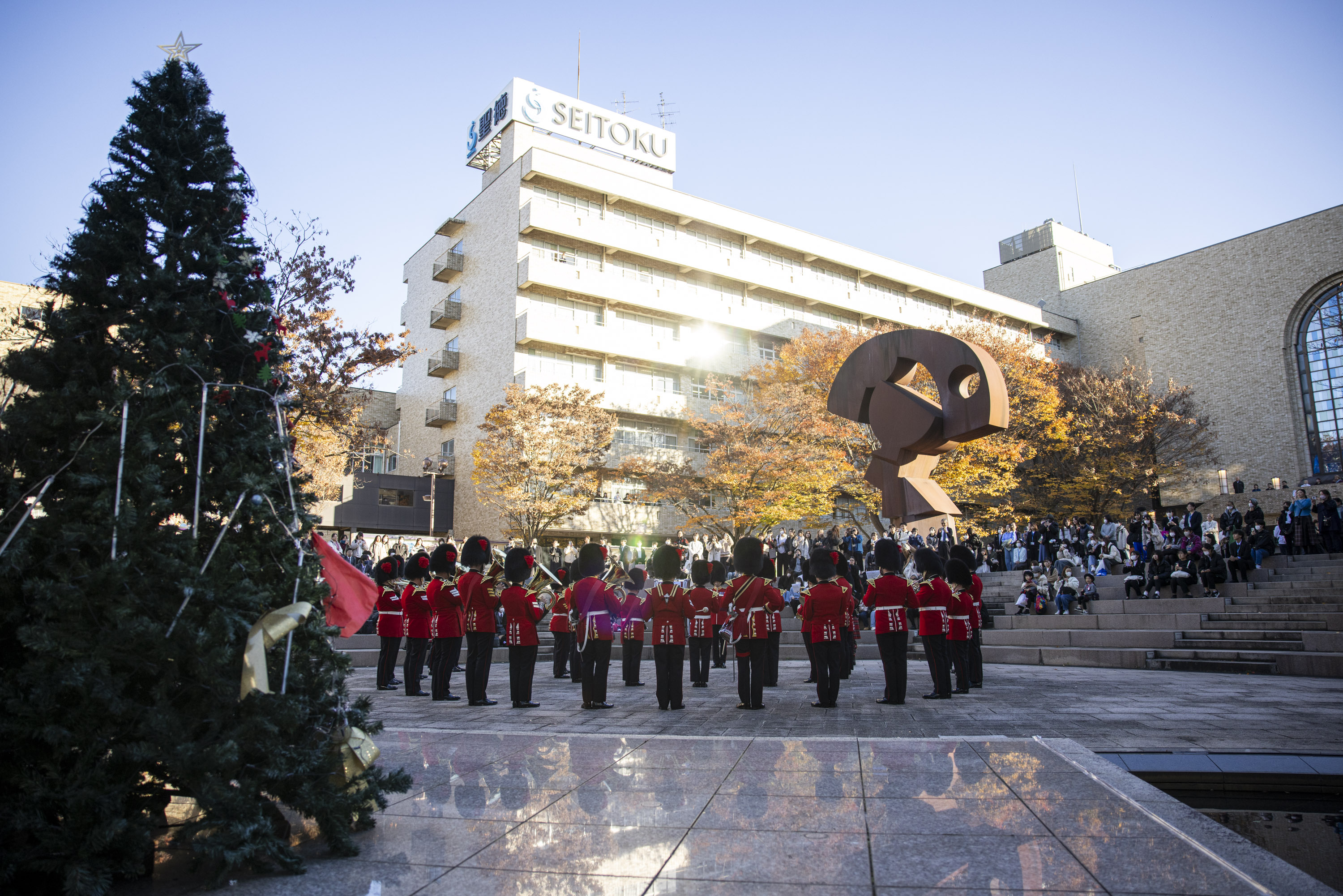 An Army band are pictured against the backdrop of a Christmas tree at a university in Japan. 
