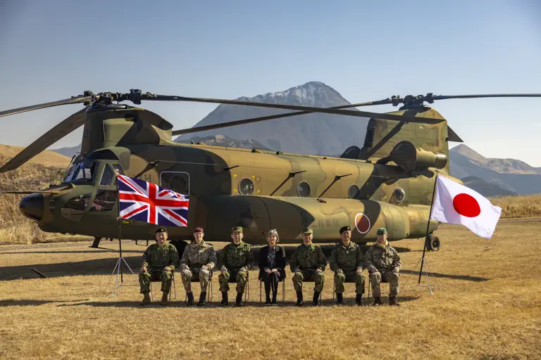 Group photo of distinguished guests (left to right) Major General Wakamatsu, 1st Airborne Brigade Commander; Brigadier Mark Berry, Commander of 16 Air Assault Brigade; General Morishita, Chief of Staff of Japanese Ground Self Defence Force; Julia Longbottom, UK Ambassador to Japan; Lieutenant General Togashi, Commander of Eastern Army; Major General Maejima, Commander of 12th Brigade; and Major Dan Ward, UK assistant defence attache in Japan. The Union Jack on the left and Japan's flag is on the right.