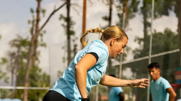 A woman in sports attire is pictured jumping in a recreational area.