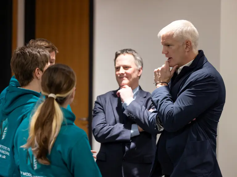 Group of people engaged in a serious discussion in an indoor setting.