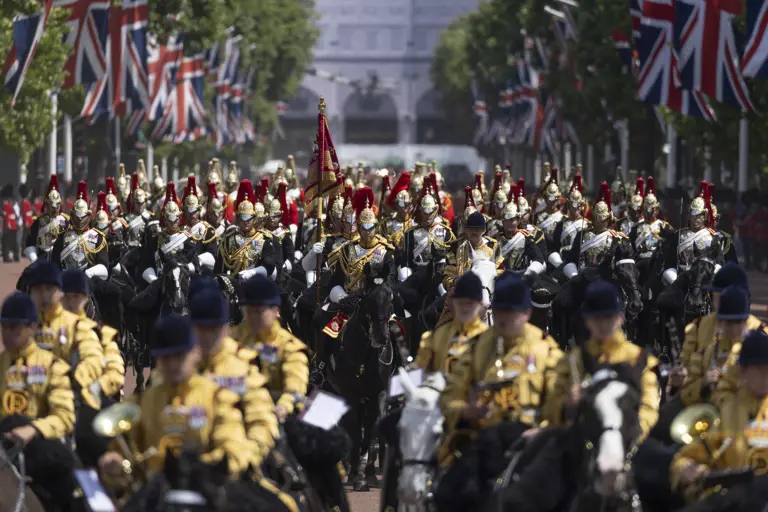 Many soldiers are pictured on horseback in ceremonial attire, some are wearing black and some are wearing yellow.
