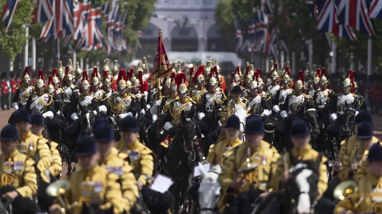 Many soldiers are pictured on horseback in ceremonial attire, some are wearing black and some are wearing yellow.