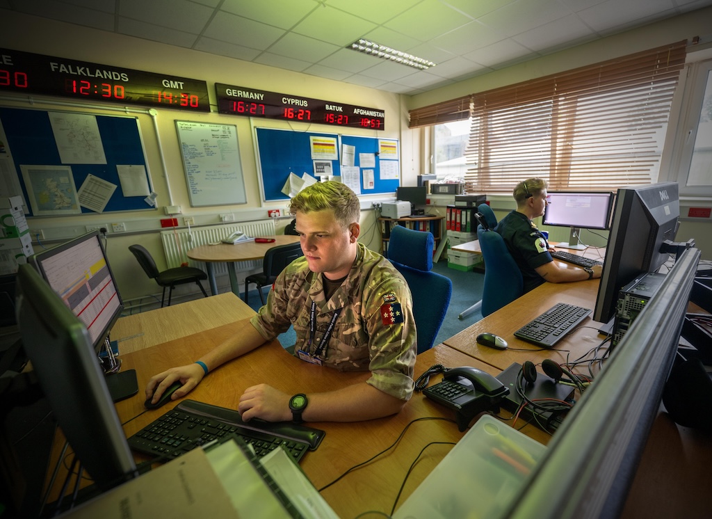 Military police soldier, and Naval colleague, working in 24 Hour Operations Room.