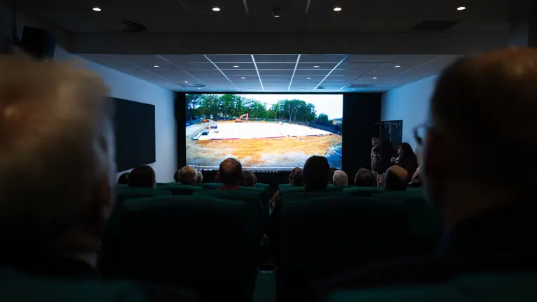 An image of a cinema screen taken from the back of the room.