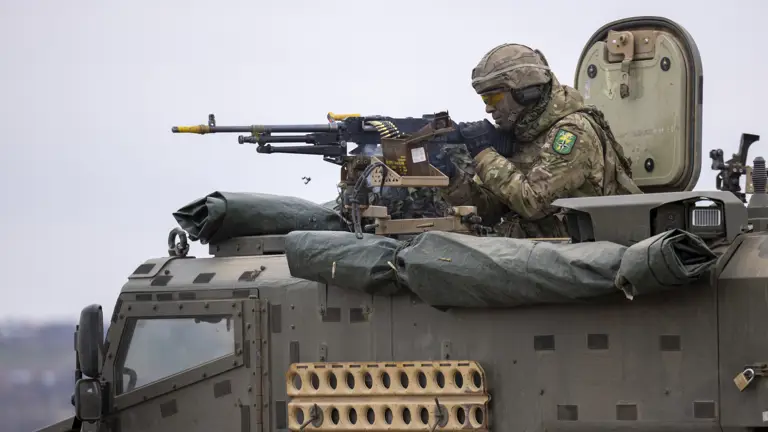 Soldier fires General Purpose Machine Gun mounted on Foxhound vehicle