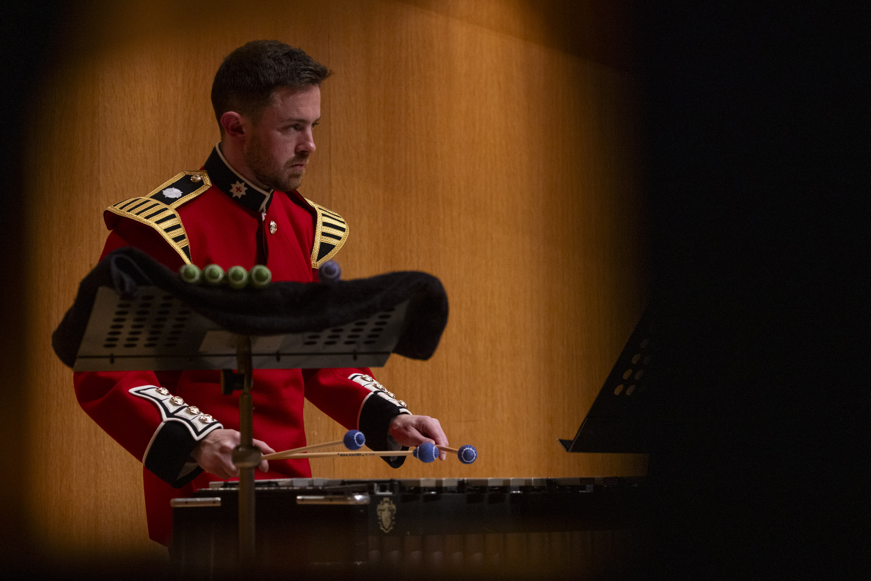 A percussionist in a red tunic plays the xylophone. 