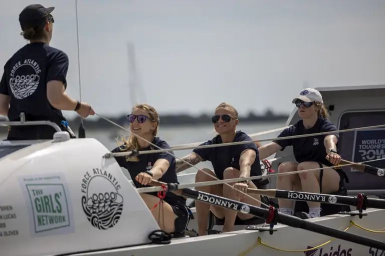 Four female soldiers are pictured rowing.