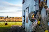 Two personnel in uniform are pictured outside of a makeshift house during an urban training drill. 