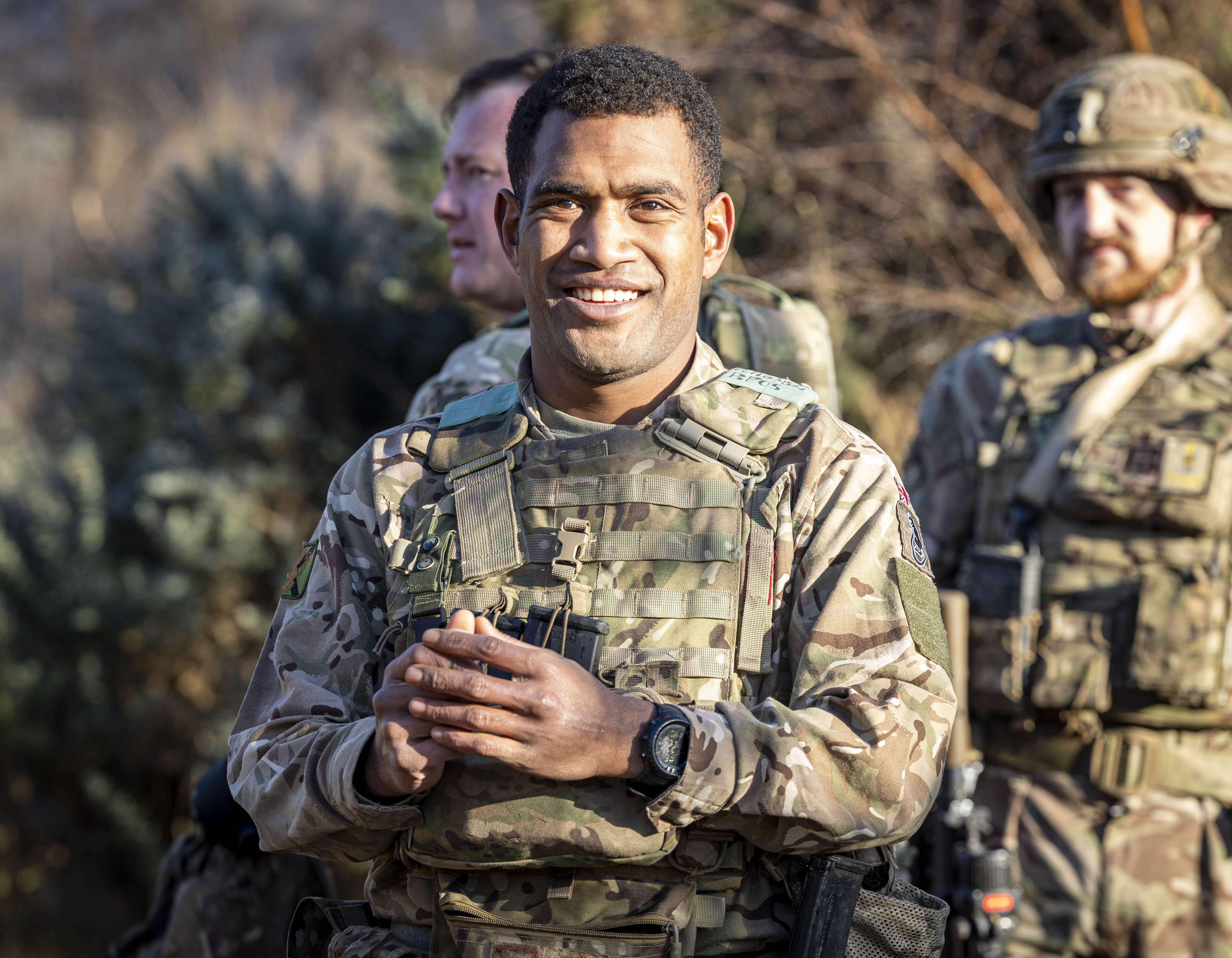 A man in uniform is pictured smiling. 