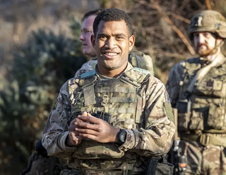 A man in uniform is pictured smiling.