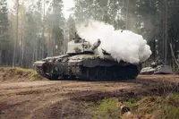 Smoke bellows from the gun of a tank.
