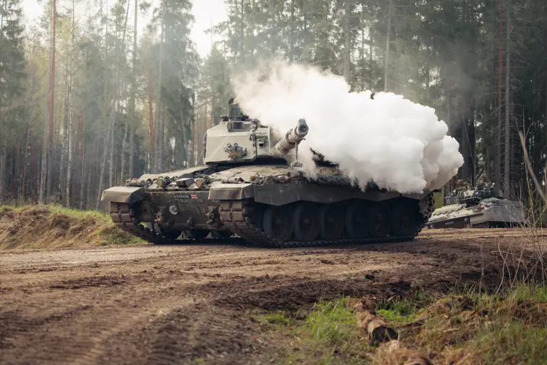 Smoke bellows from the gun of a tank. 