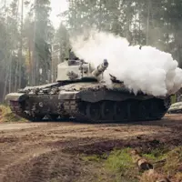 Smoke bellows from the gun of a tank.