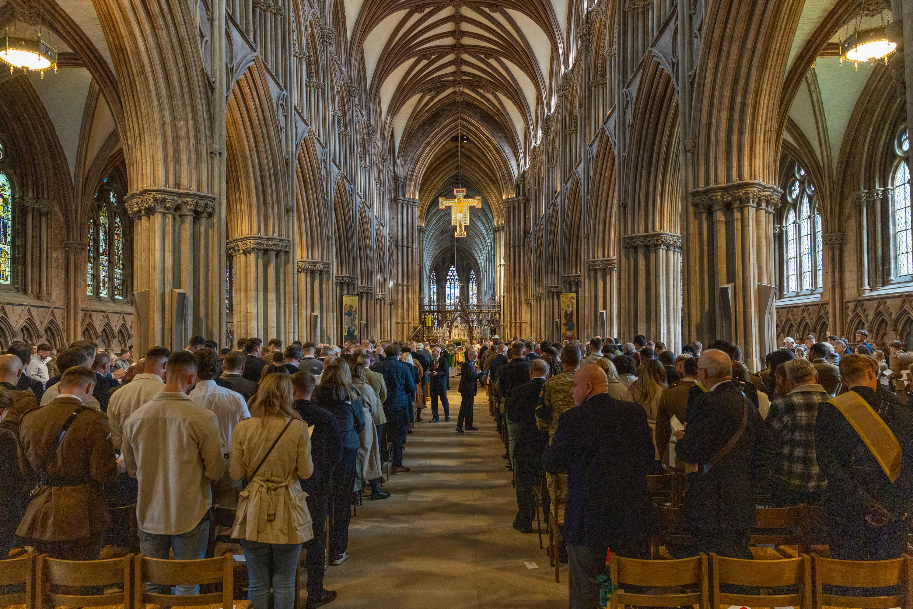 Inside the cathedral soldiers and guests line the chairs each side of the aisle. The colours are being marched down the aisle in uniform.
